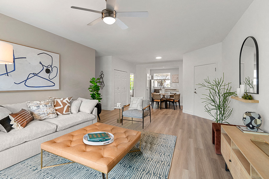 A living room with a couch, a coffee table, and a painting on the wall.